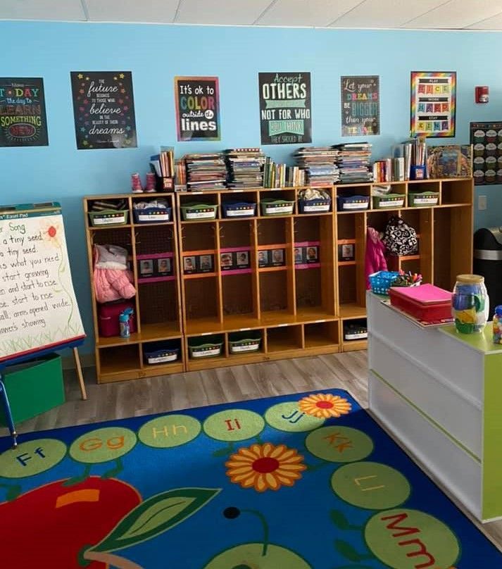A classroom with a blue wall and a blue rug