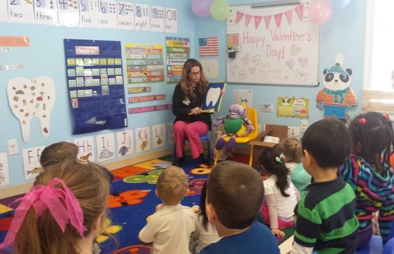 A woman is reading a book to a group of children