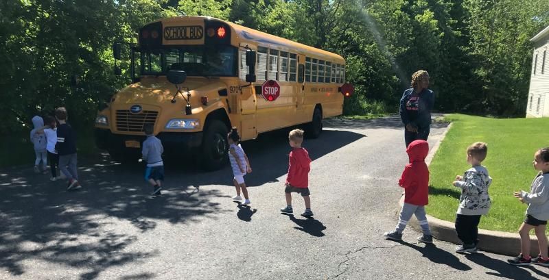 A group of children are walking towards a school bus.