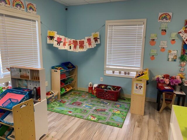 A room with a lot of toys and a rug on the floor.