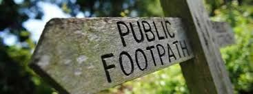 A wooden sign pointing to the right says public footpath.