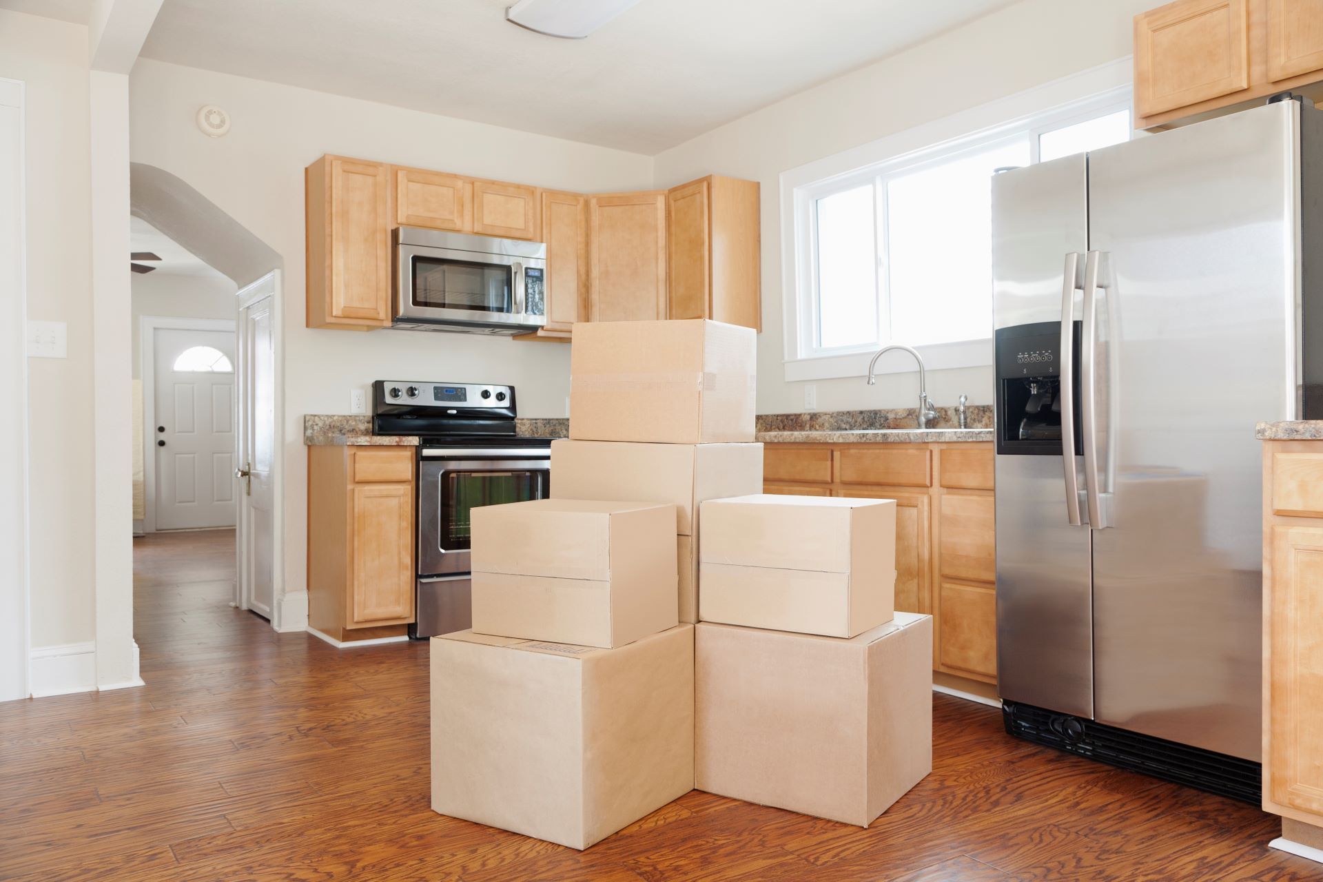 A kitchen with boxes stacked on top of each other.