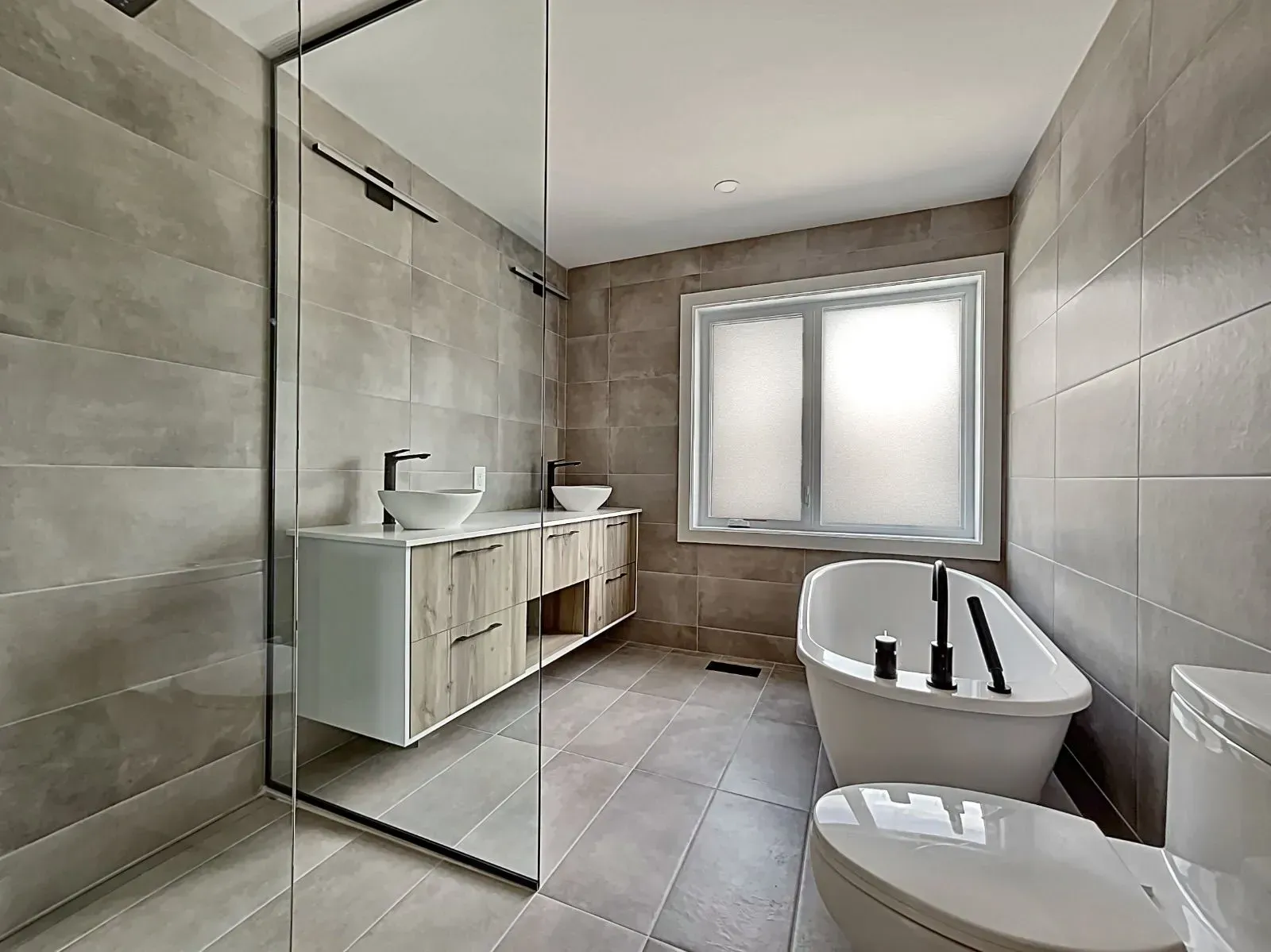 A bathroom with a tub , toilet , sink and shower.
