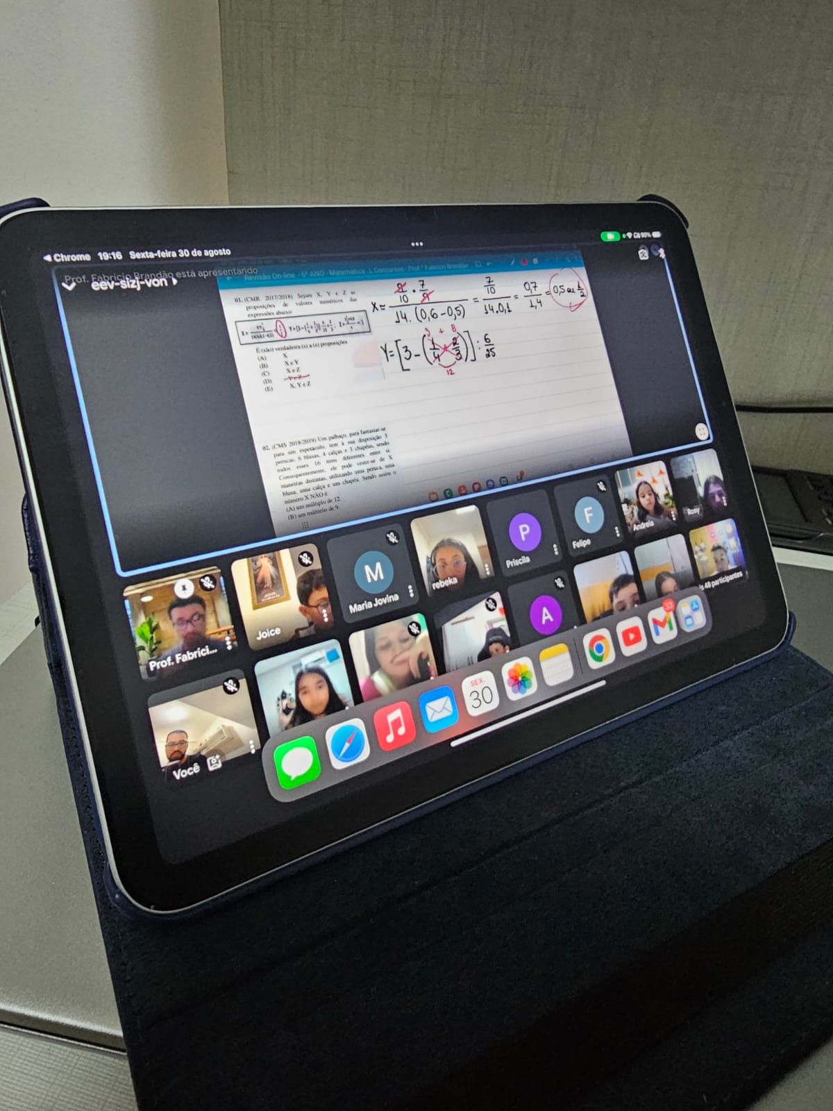 Um tablet está aberto para uma videochamada com muitas pessoas nele