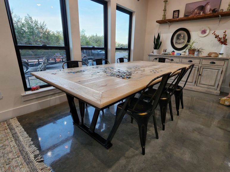 A dining room with a table and chairs and a lot of windows.