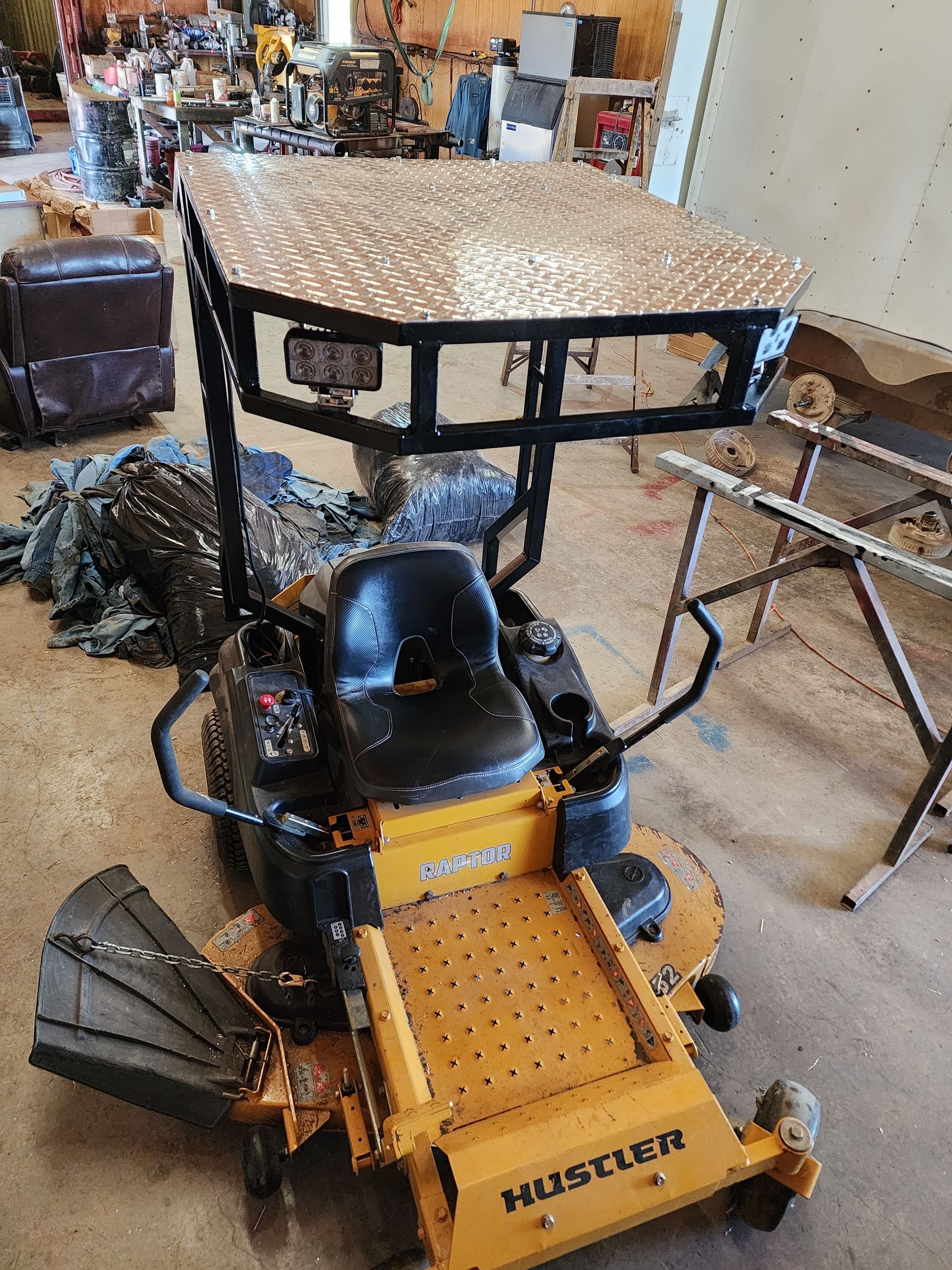 A yellow lawn mower is sitting on the floor in a room.