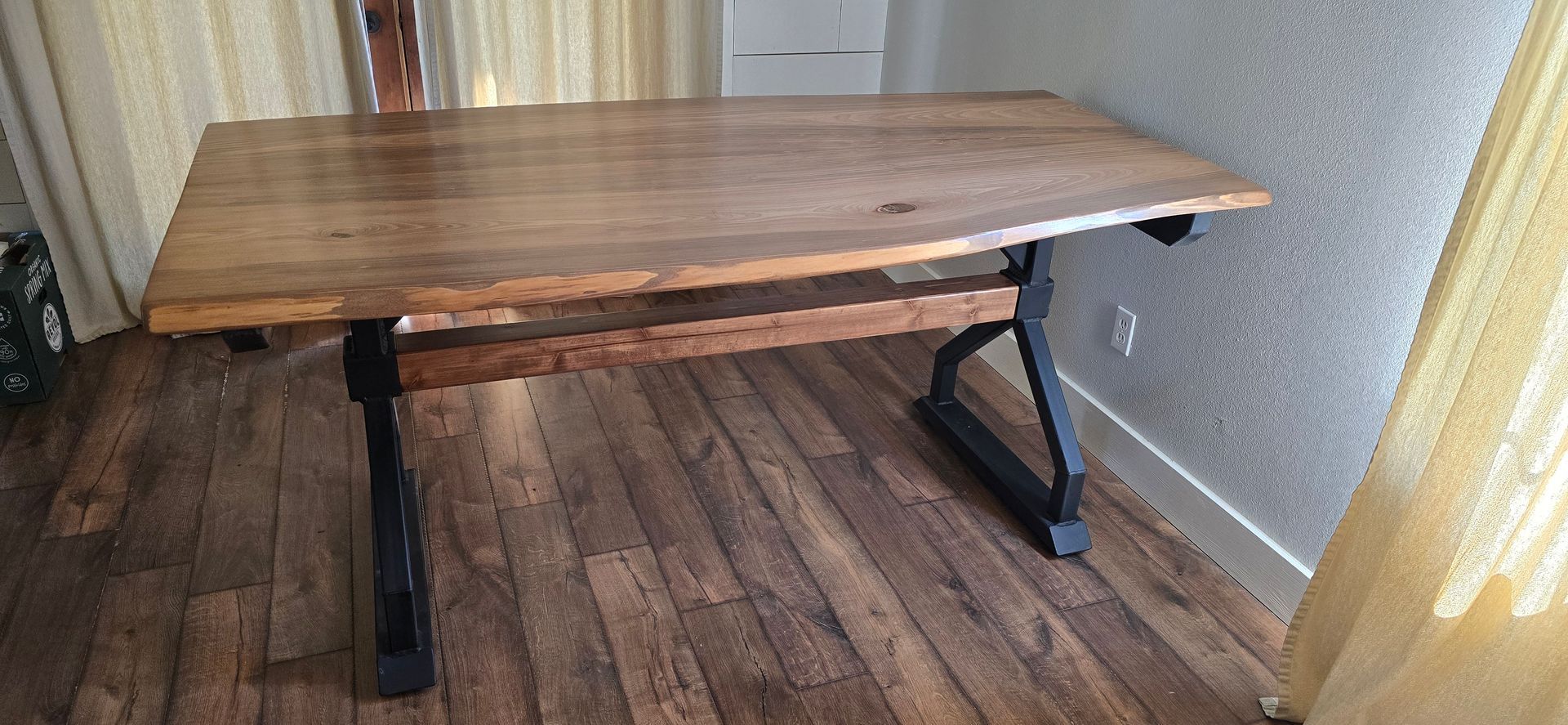 A wooden table is sitting on a wooden floor in a room.