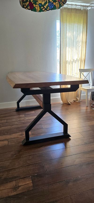 A wooden table is sitting on a wooden floor in a dining room.