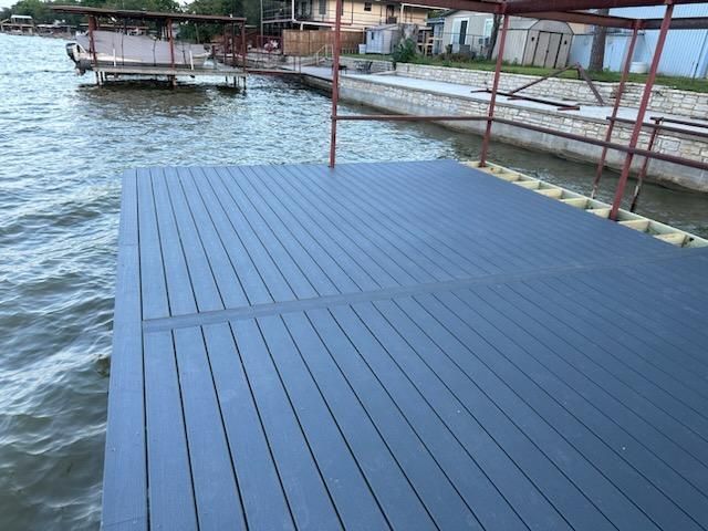 A dock on a lake with a boat in the background