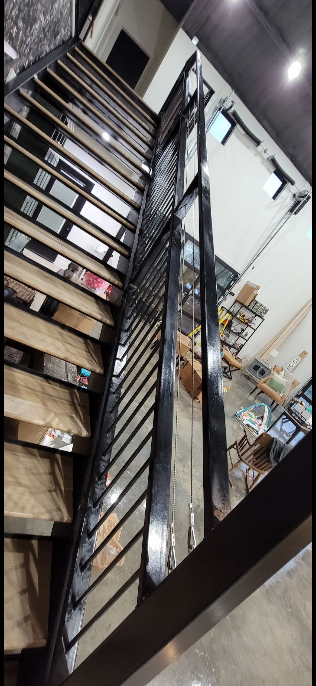 A staircase with a metal railing and wooden steps in a building.