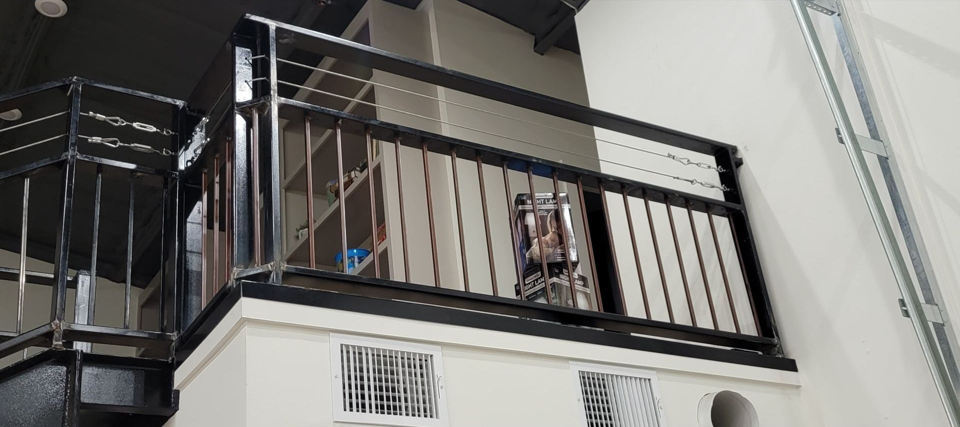A balcony with a black railing on a white building.