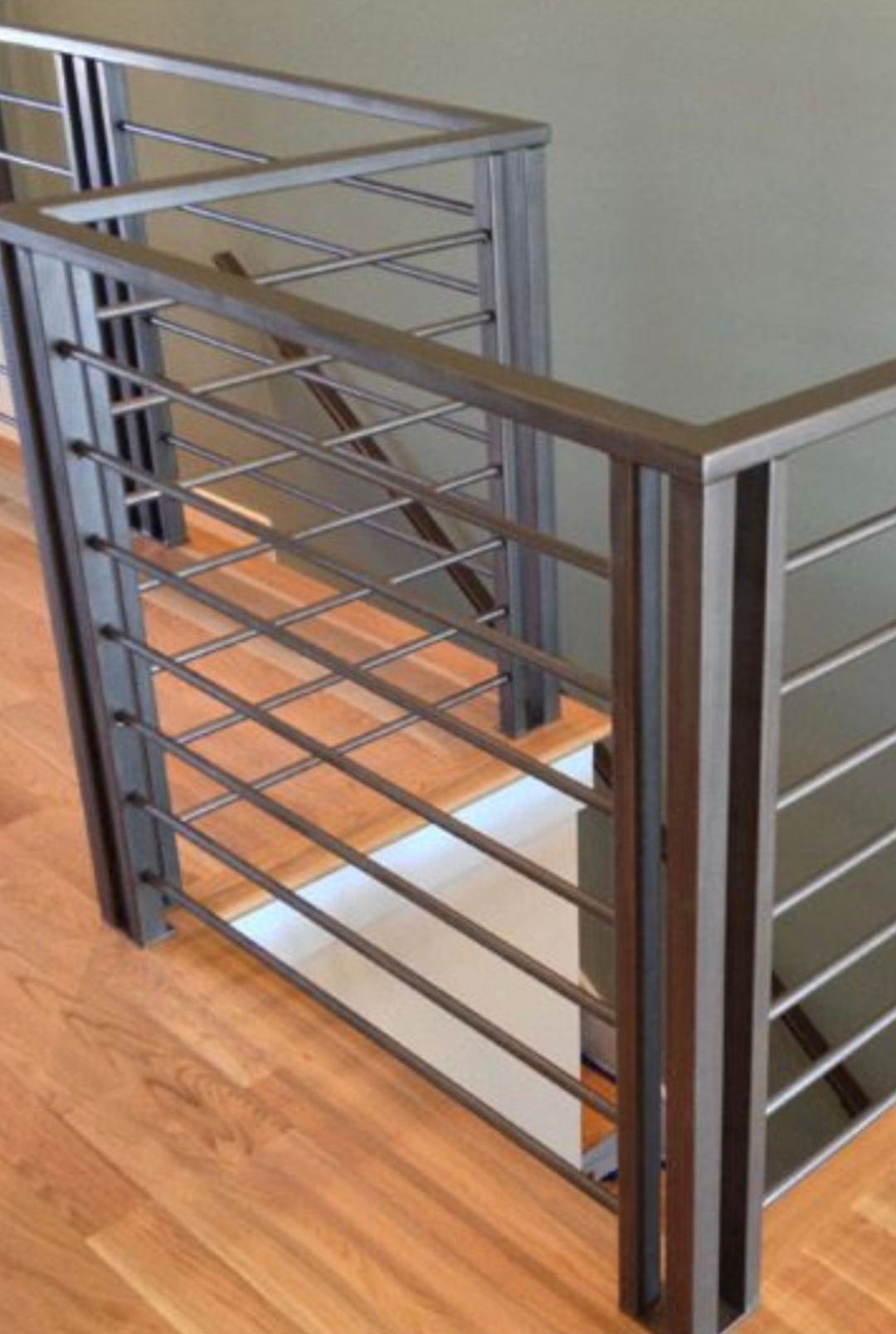 A staircase with a metal railing and a wooden floor
