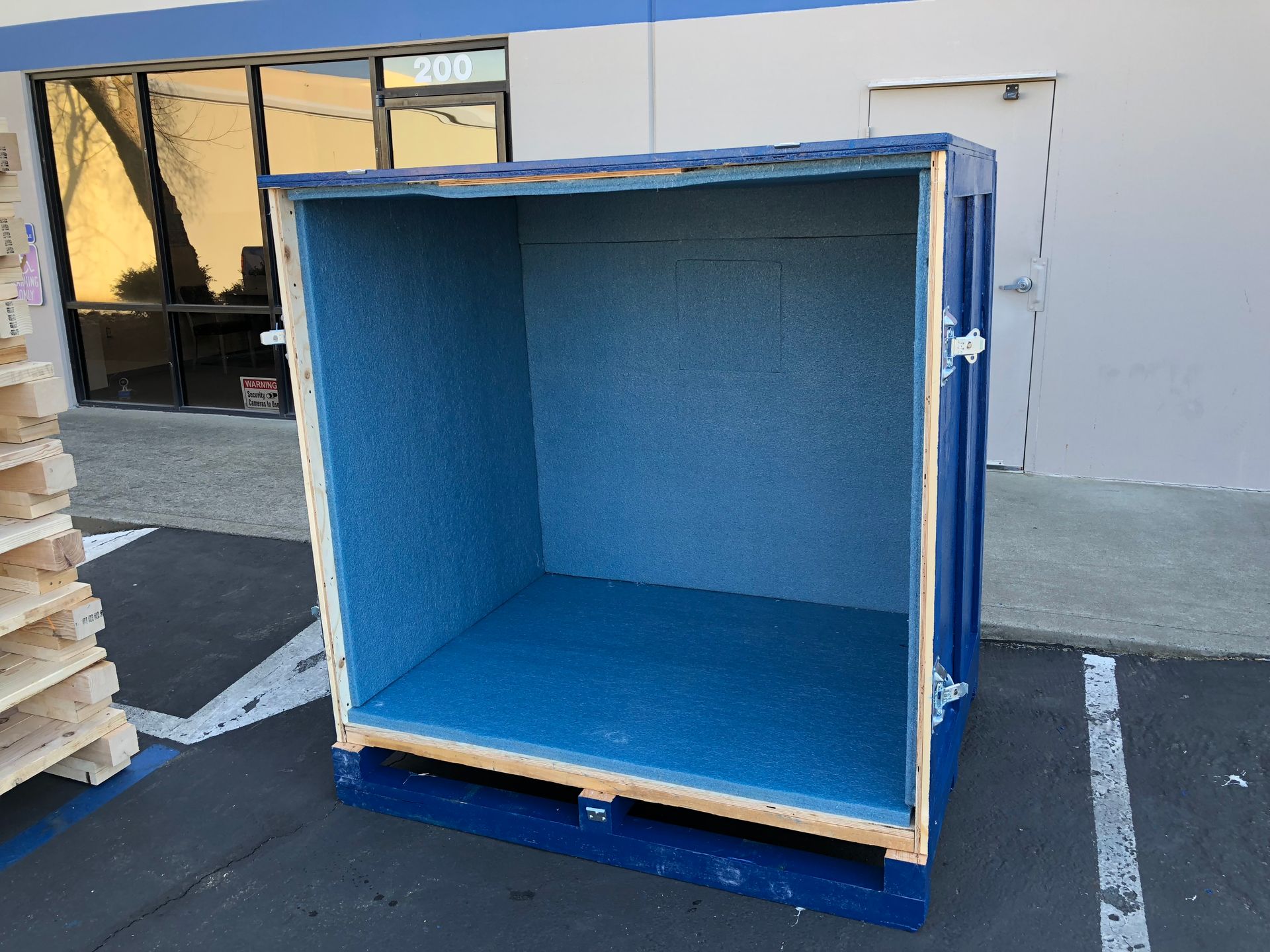 Black foam inserts, cut in various shapes, on a wooden workbench in a factory setting.