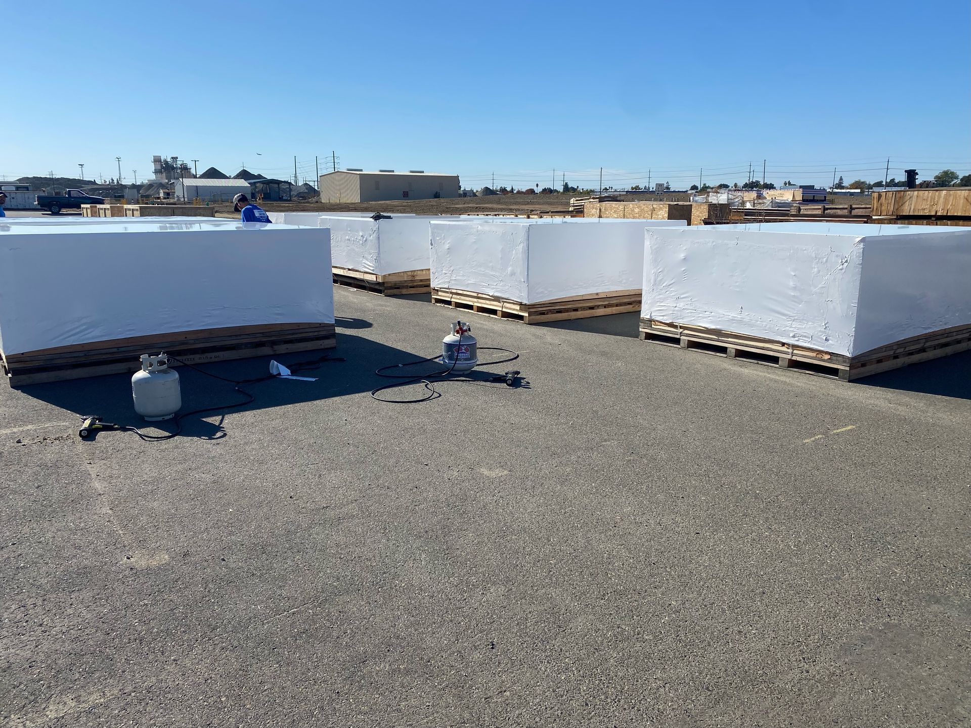 Large, silver-wrapped objects on wooden pallets in a warehouse.