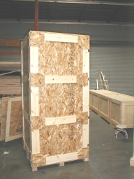 Large wooden shipping crate on a pallet in a warehouse.