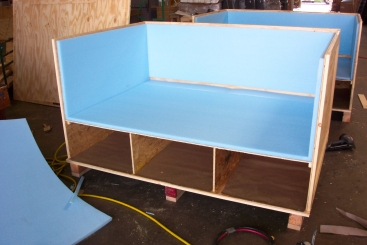 Wooden crates with blue foam interiors in a workshop setting.