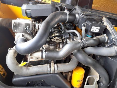 Close-up view of a yellow and black engine with various black hoses and a yellow oil filter.