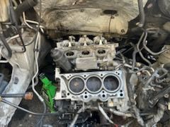 Engine with cylinder head removed, showing exposed cylinders and various components.