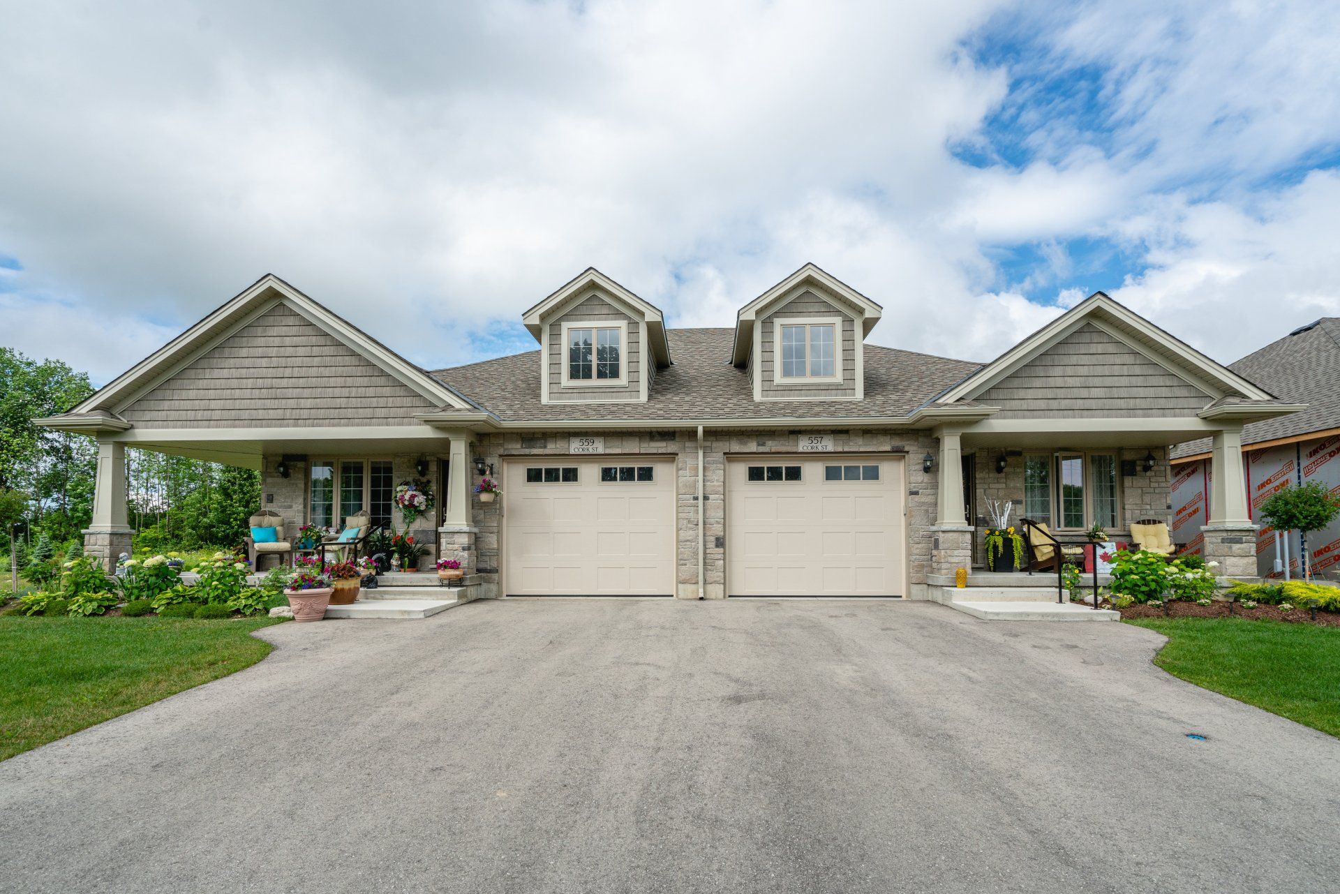 A large house with two garages and a driveway in front of it.