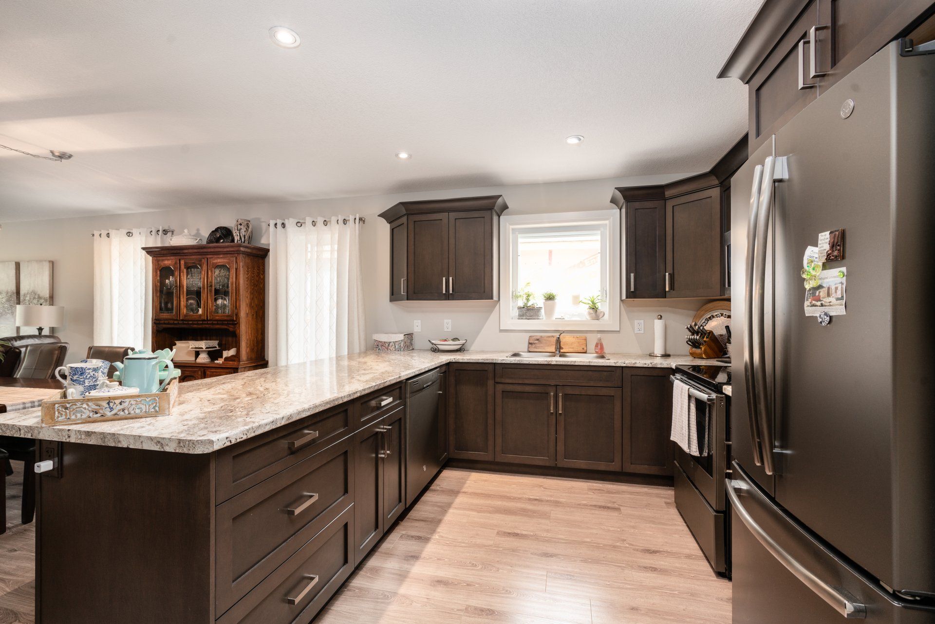 A kitchen with a large island and a black refrigerator