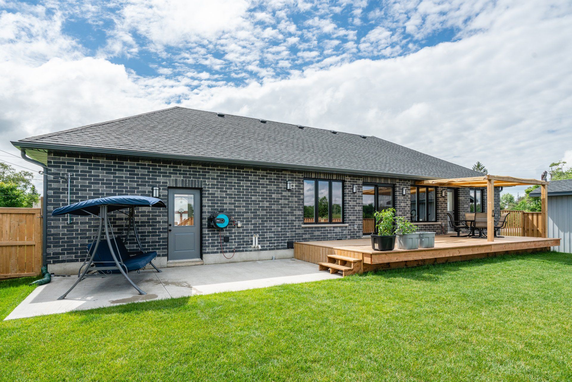 The backyard of a house with a swing and a deck.
