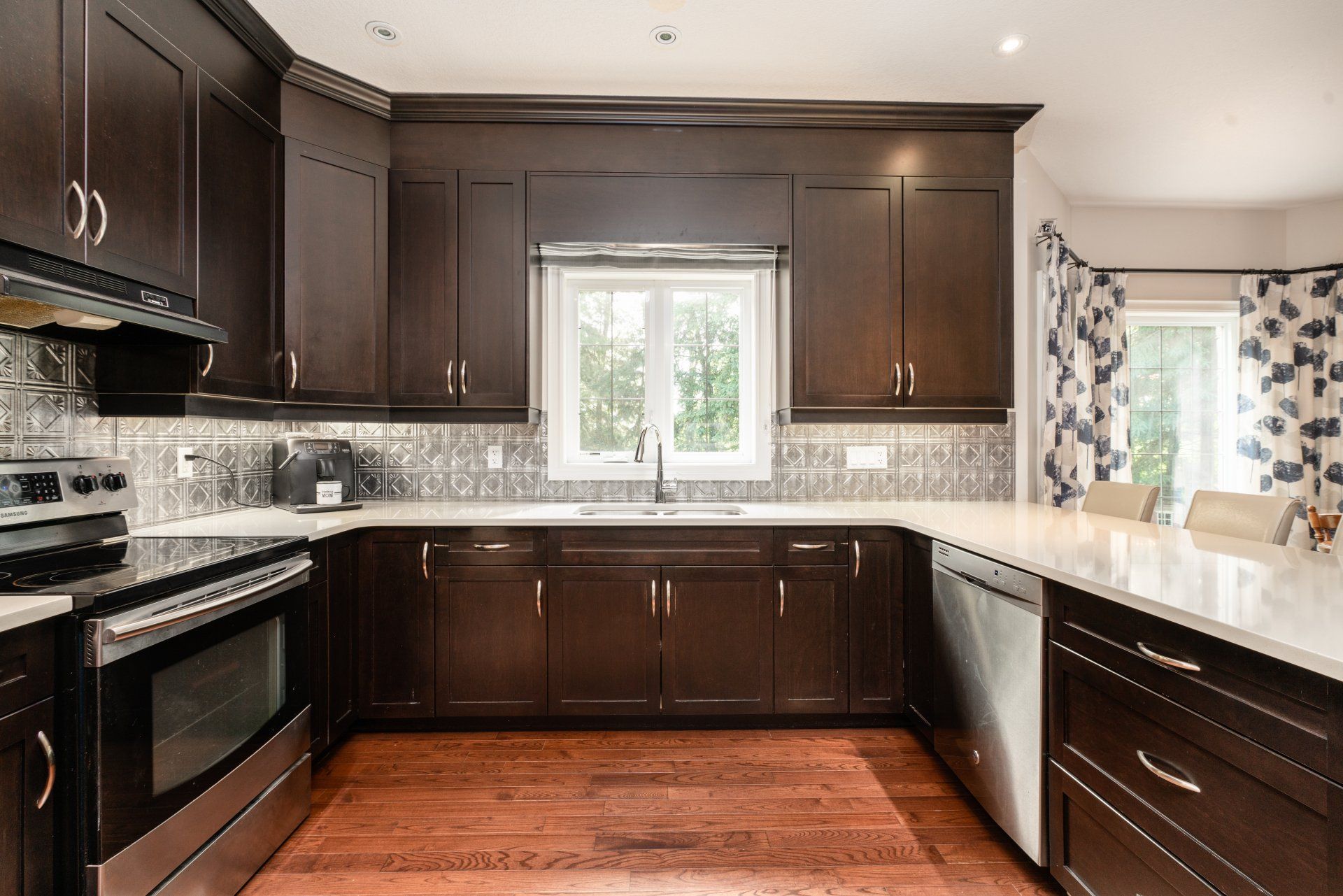 A kitchen with wooden cabinets , stainless steel appliances , a sink , and a window.