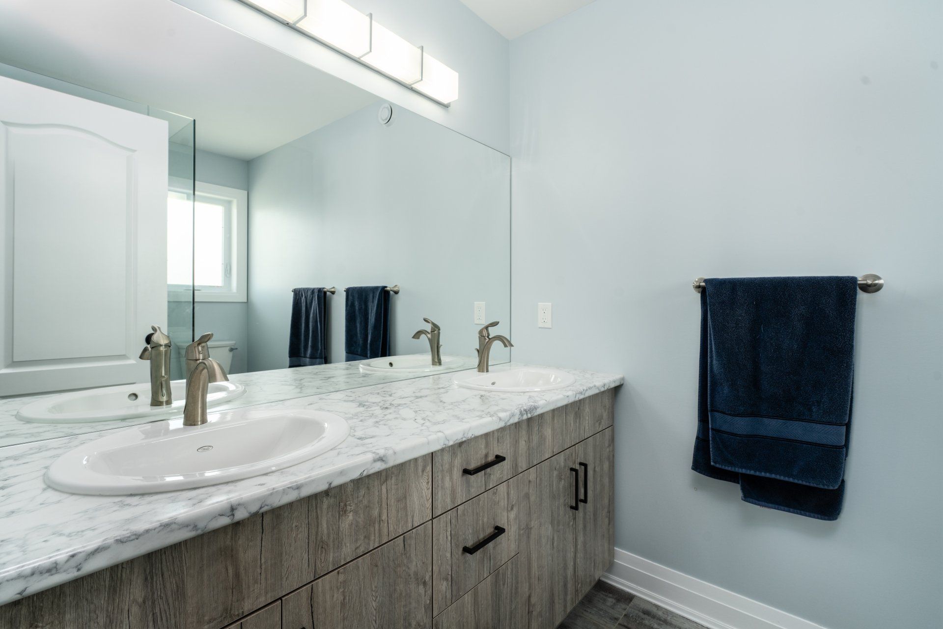 A bathroom with two sinks and a large mirror.