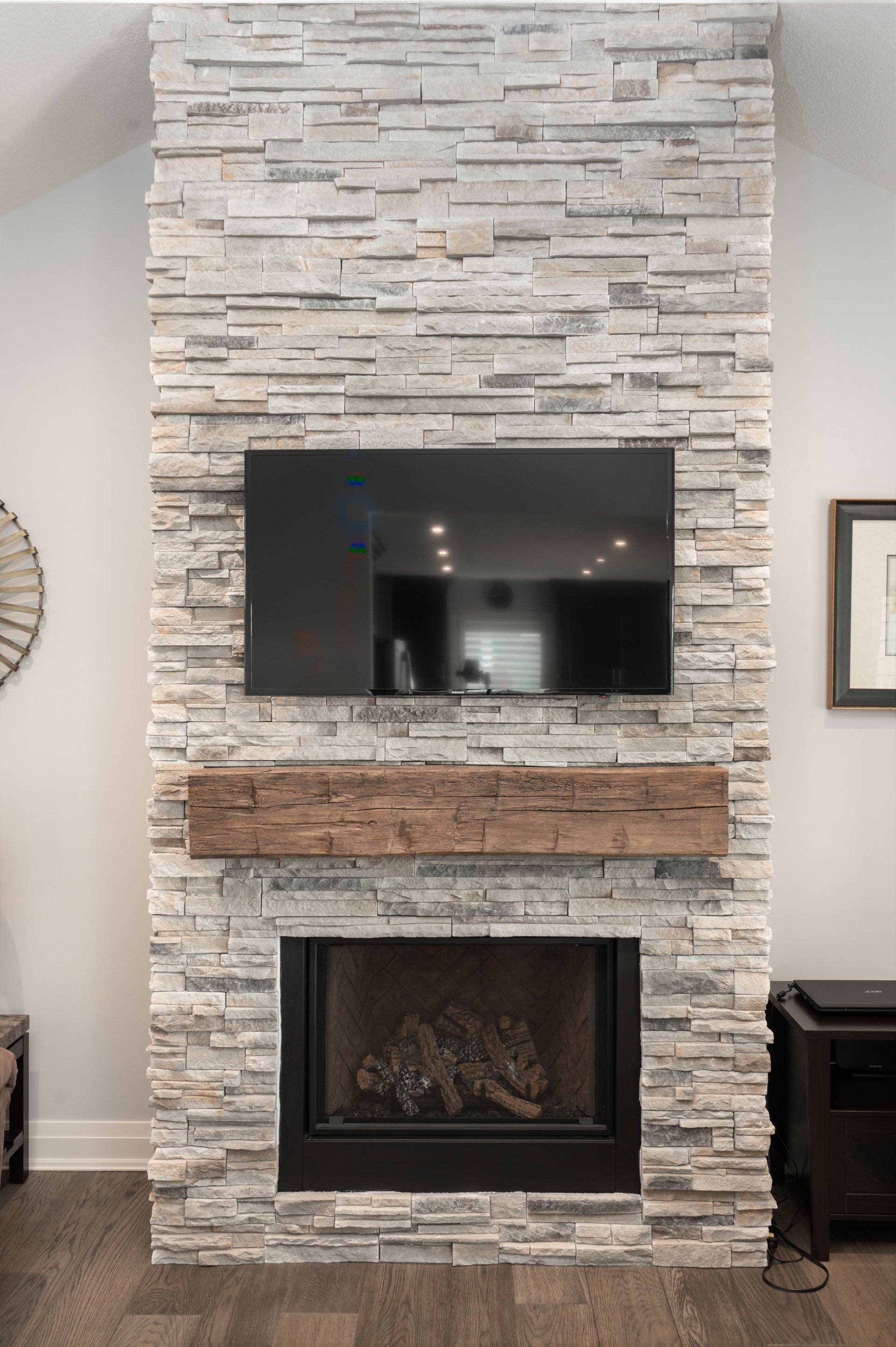 A living room with a fireplace and a flat screen tv mounted on the wall.