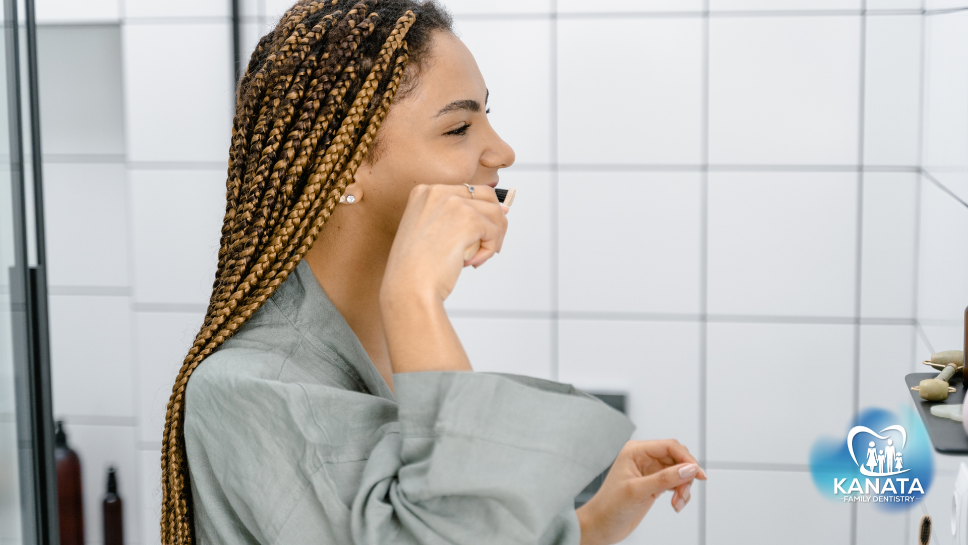 A woman is brushing her teeth in front of a mirror in a bathroom.