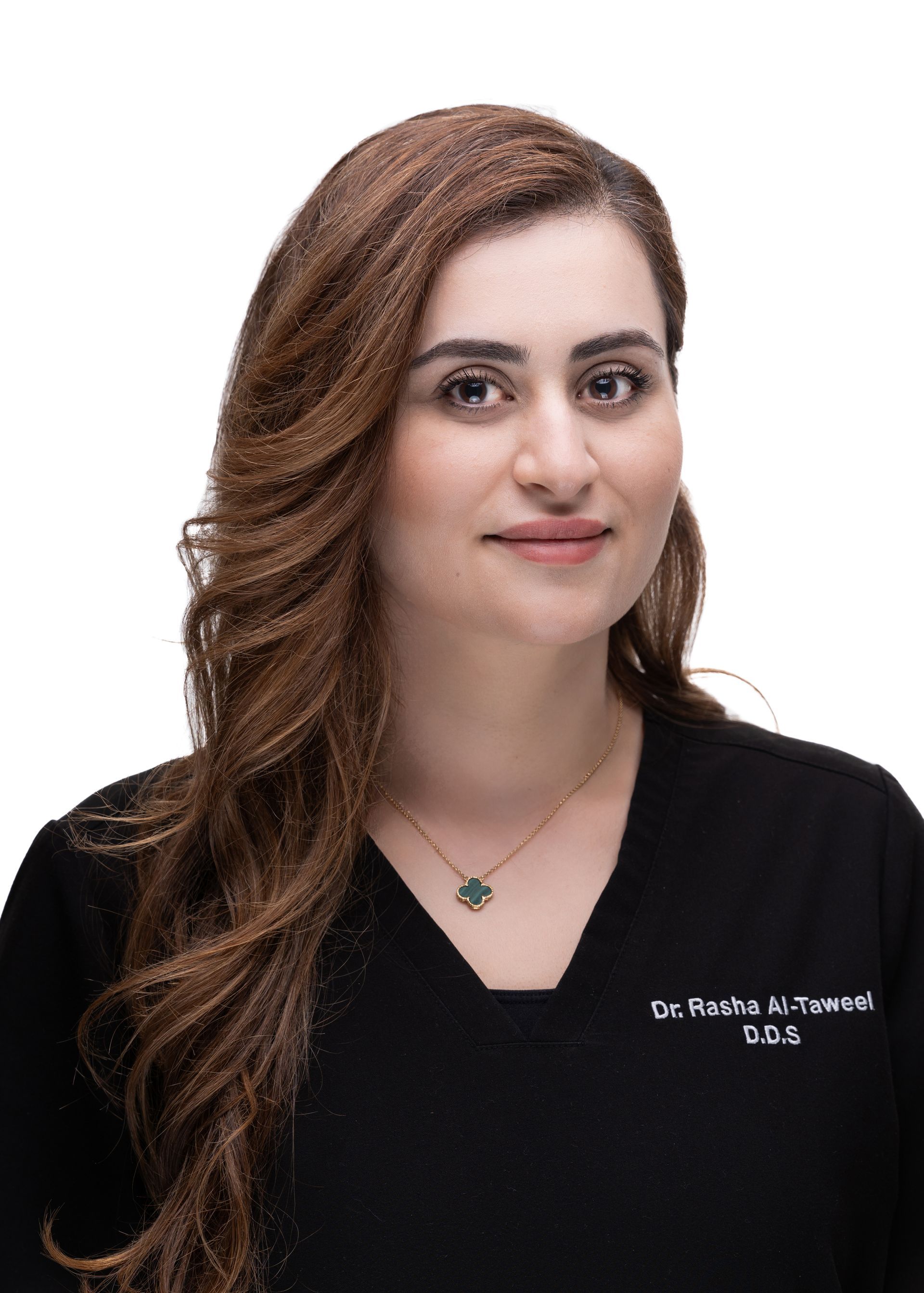 A woman with long hair is wearing a black scrub top and a necklace.