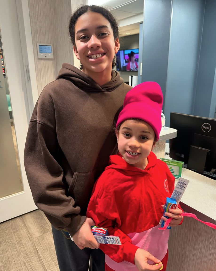 Two kids smiling in an indoor office - Riverdale Pediatric Dentistry