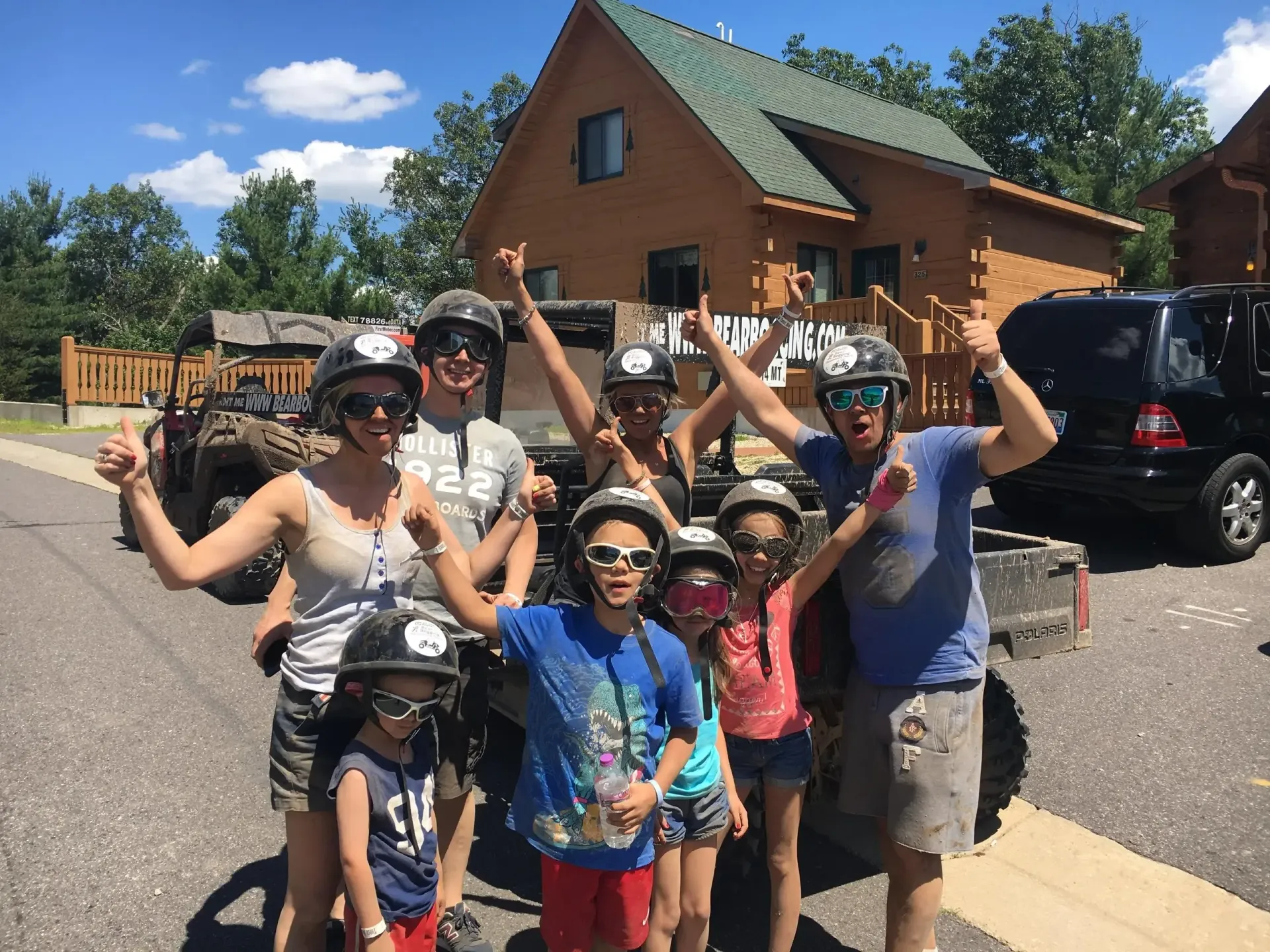 A group of people wearing helmets are standing in front of a house.