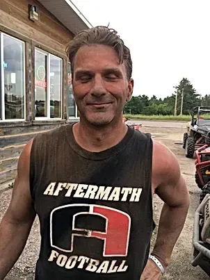 A man is wearing a tank top that says aftermath football.