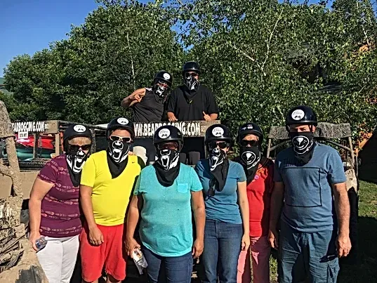 A group of people wearing masks and helmets are posing for a picture.