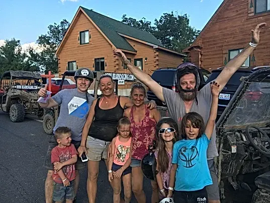 A group of people are posing for a picture in front of a house.