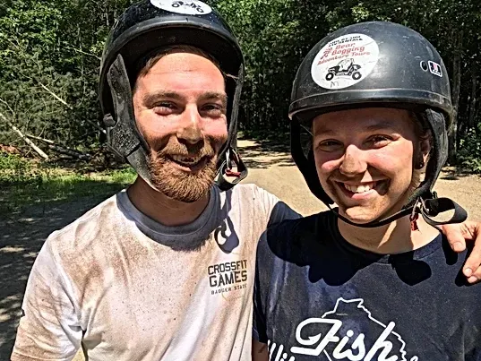 A man and a woman wearing helmets are posing for a picture.