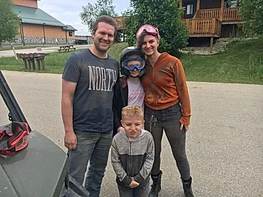 A family is posing for a picture in front of a house.