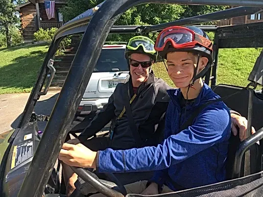 A man and a boy are sitting in a buggy.
