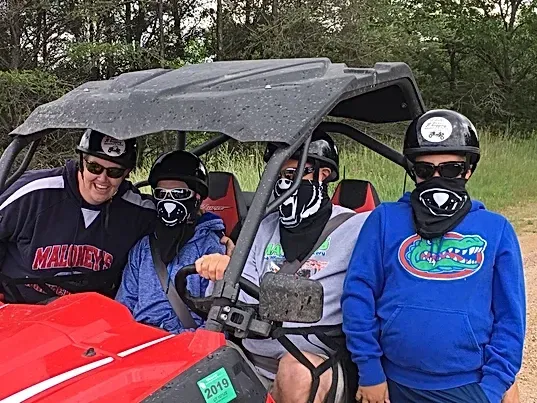 A group of people are sitting in a red atv.