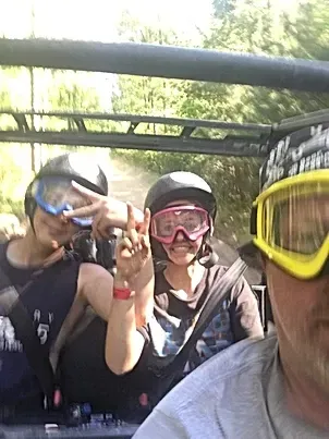 A group of people wearing goggles and helmets are sitting in a vehicle.