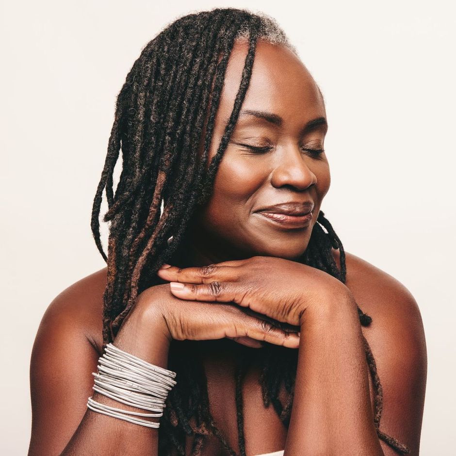 A woman with dreadlocks and bracelets on her wrists.