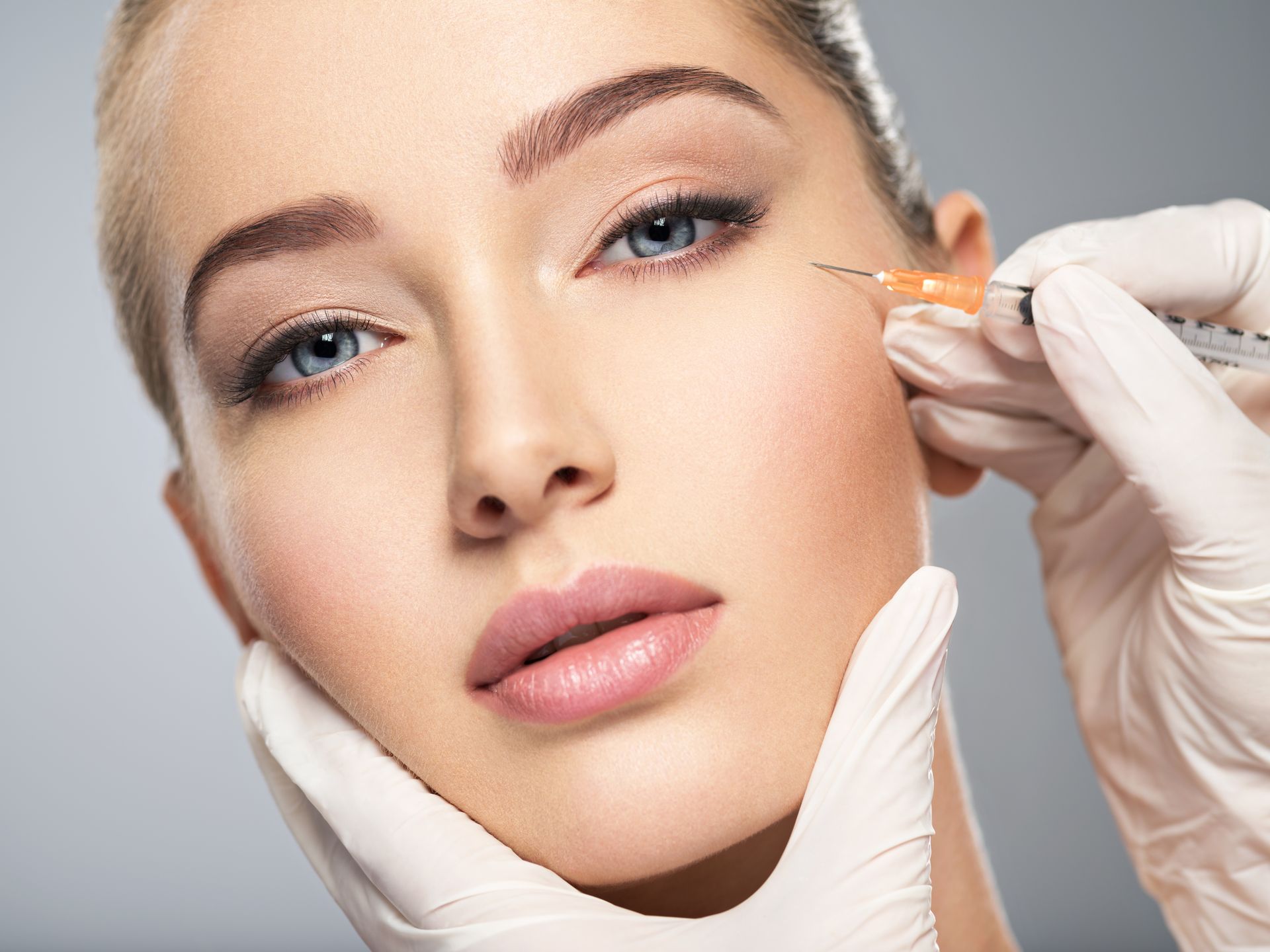 A woman is getting a botox injection in her face.