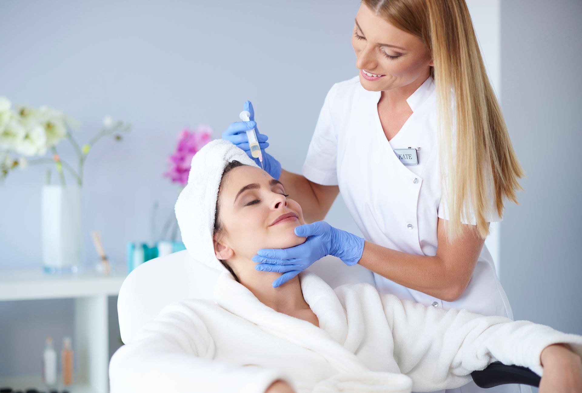 A woman is getting an injection in her face at a beauty salon.