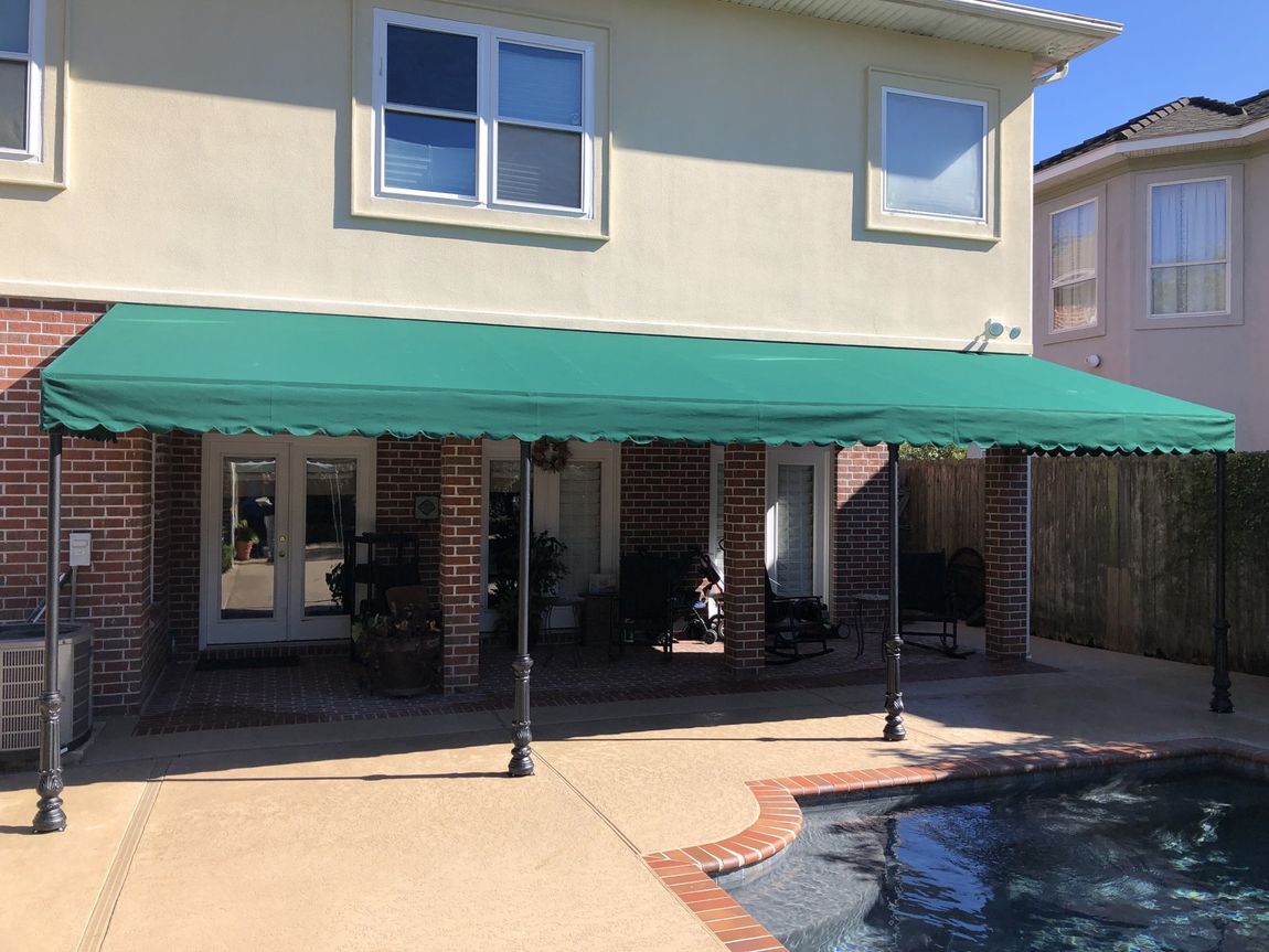 Custom Awnings — Two Story Building With Green Awning Installed in Chalmette, LA
