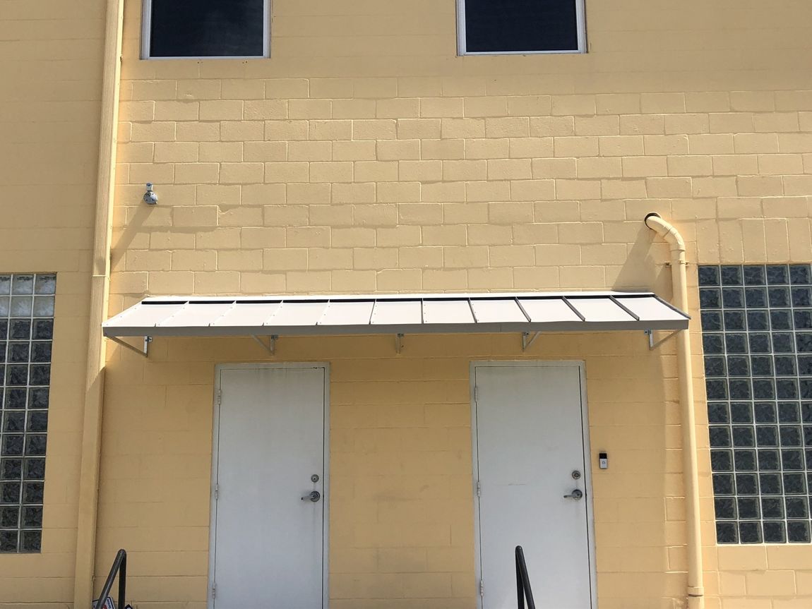 Foster Awnings — Simple White Awnings Installed On Two Doors in Chalmette, LA