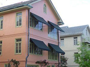 Awning Covers — Two Story House With Awning On The Windows in Chalmette, LA