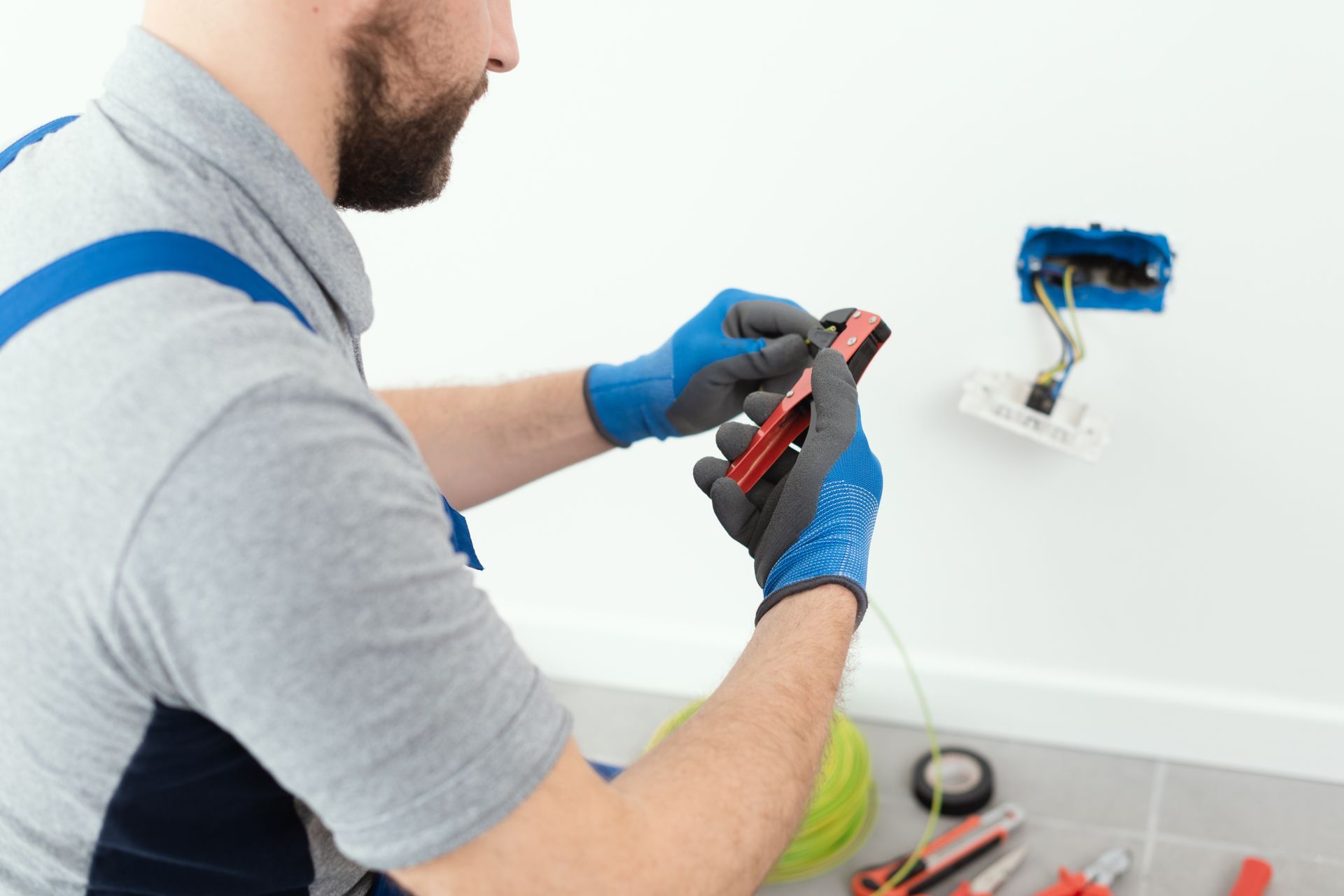 A partial view of a professional Electrician working on an electrical power point. A partial view of a professional Electrician working on an electrical power point.