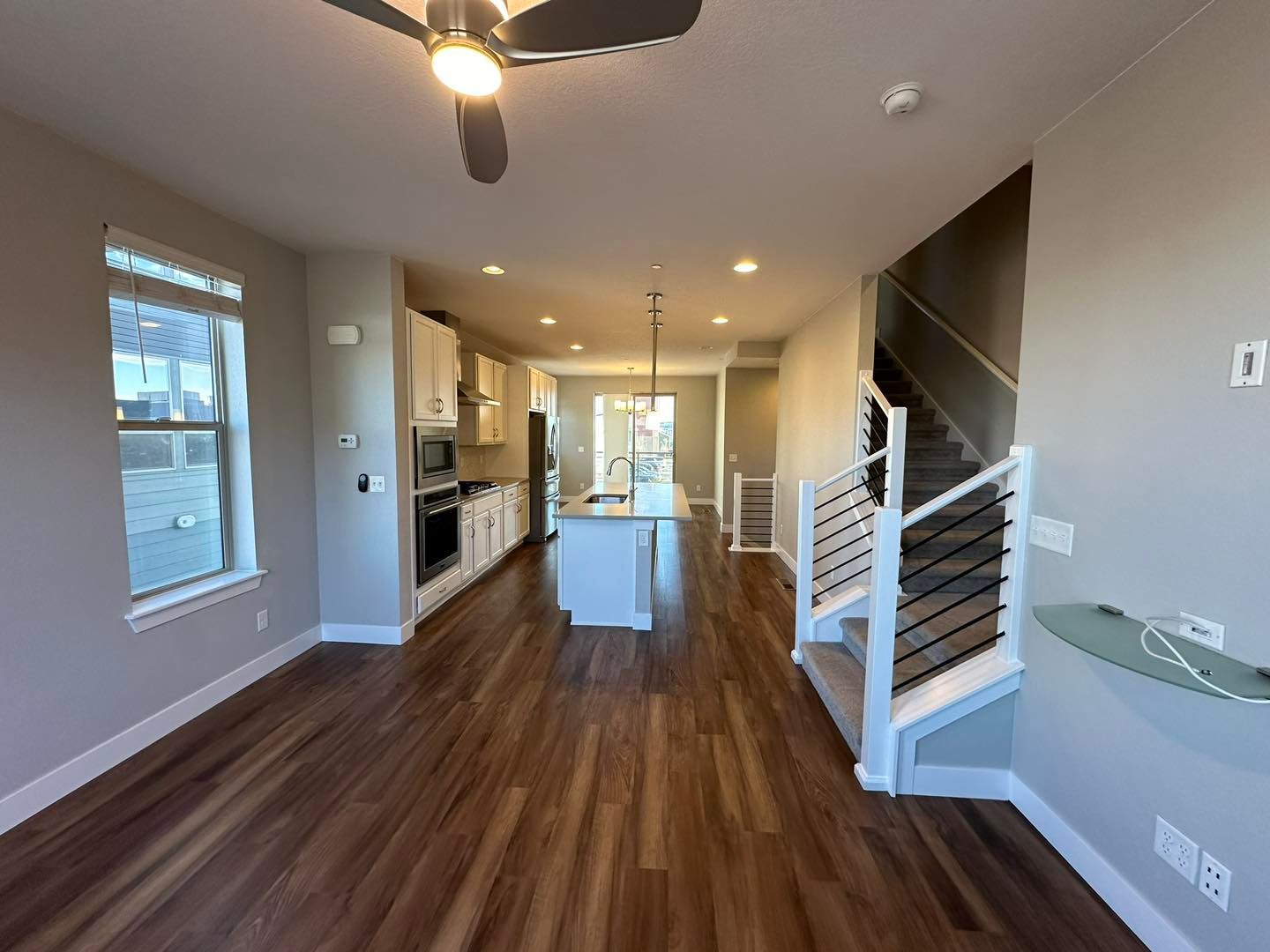 Modern interior with hardwood floors, kitchen, island, and staircase.