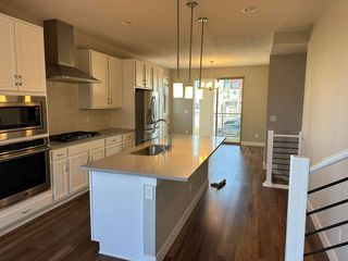 Modern kitchen with white cabinets, stainless steel appliances, and an island.