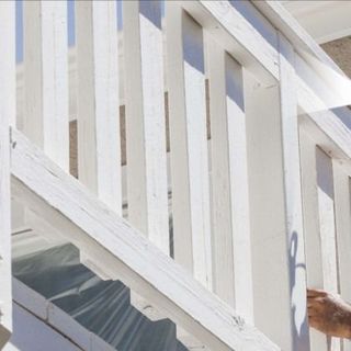 White painted wooden railing on steps, bright sunlight.